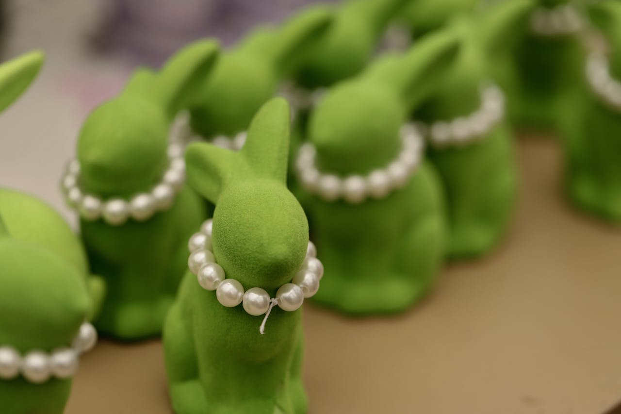 Vibrant green bunny figures adorned with pearl necklaces, perfect for celebrating Easter and spring festivities.